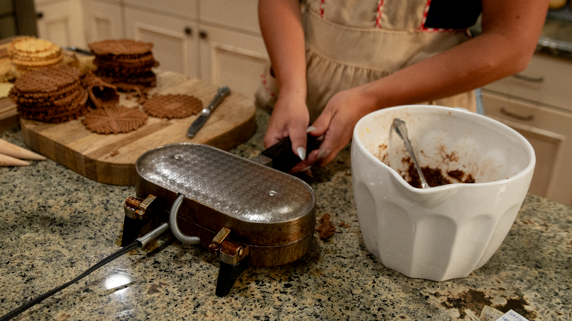 Hands making pizzelles, three generations of bakers