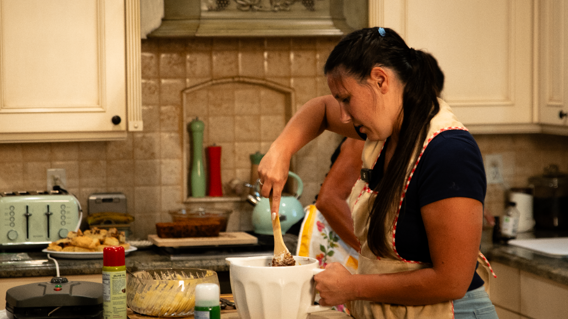Brandi baking in her home kitchen, stirring a bowl at the counter
